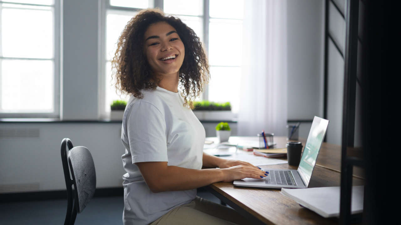 Mulher sorrindo em frente ao notebook