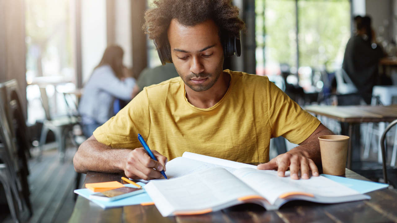 Jovem negro estudando em biblioteca