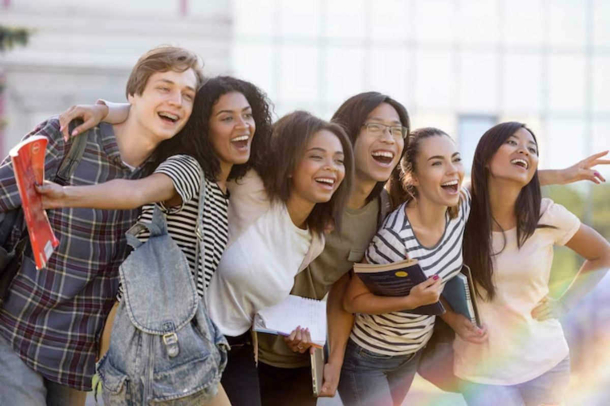 Um grupo de estudantes tira foto junto no jardim da universidade