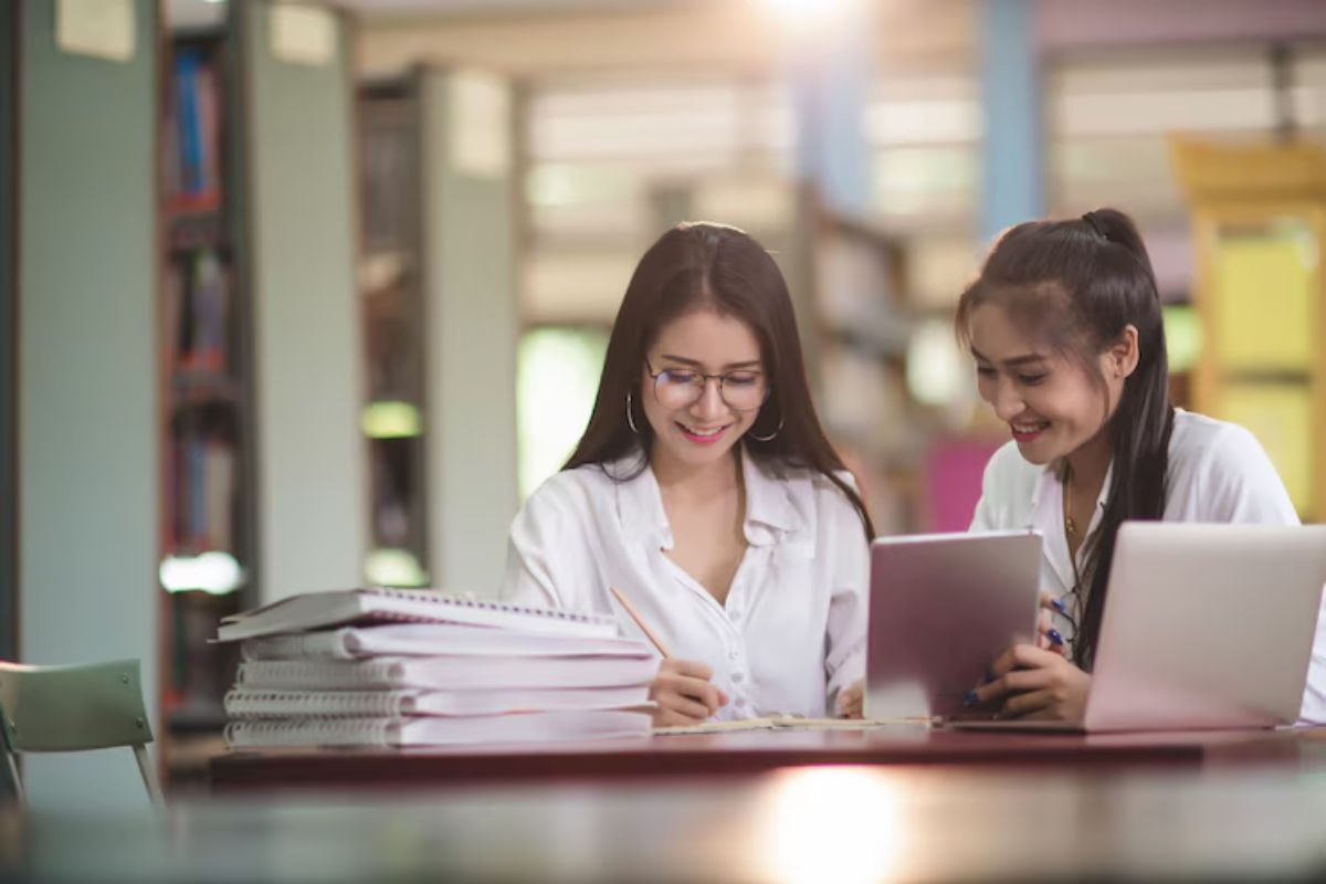 Duas amigas na sala de estudos conferem em um notebook o cronograma SISU 2025