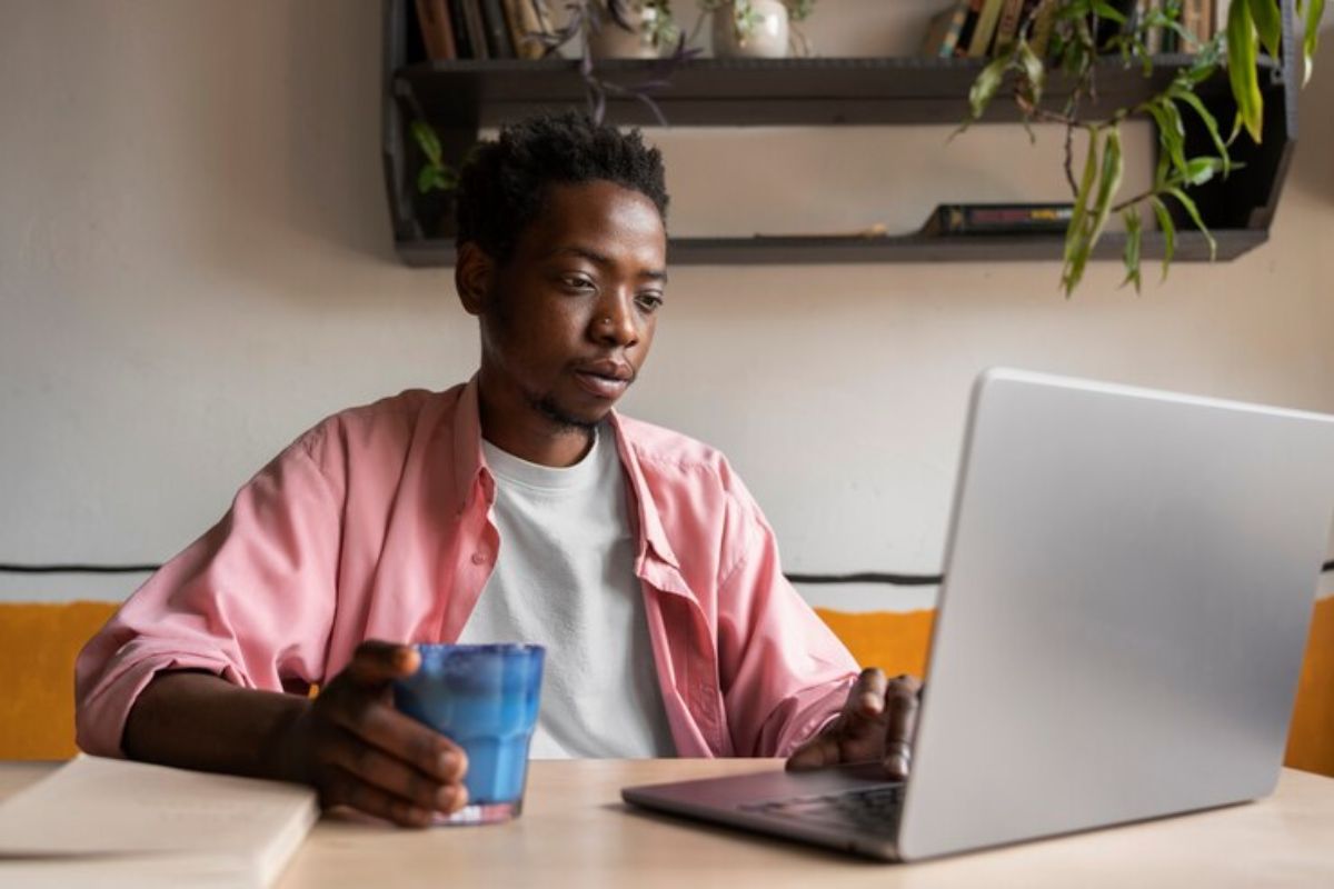 Um estudante em casa usando o seu notebook para ver dicas para melhorar suas chances de ser aprovado no SISU 2025