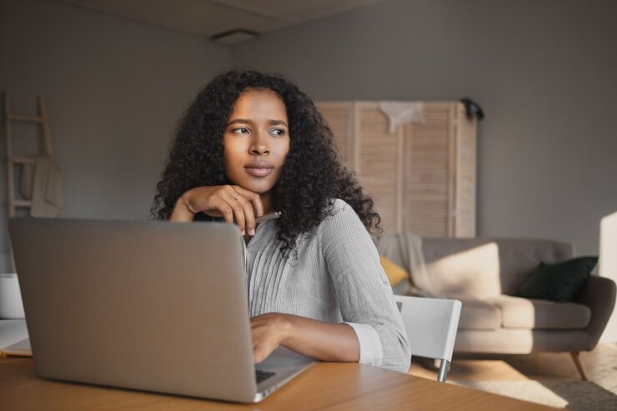 Uma estudante em sua casa consulta o notebook