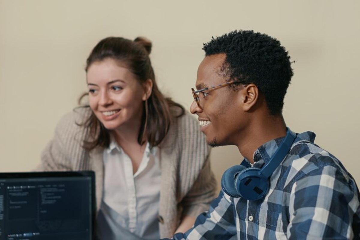 Dois estudantes em frente a um computador na sala de estudos conversam sobre o que fazer com o resultado do SISU